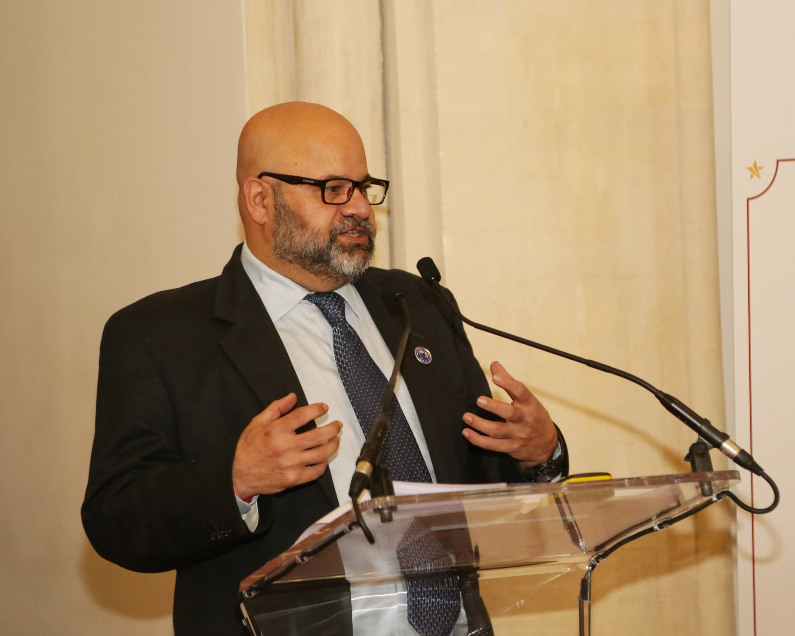 Asjad Sheikh speaking at a lectern
